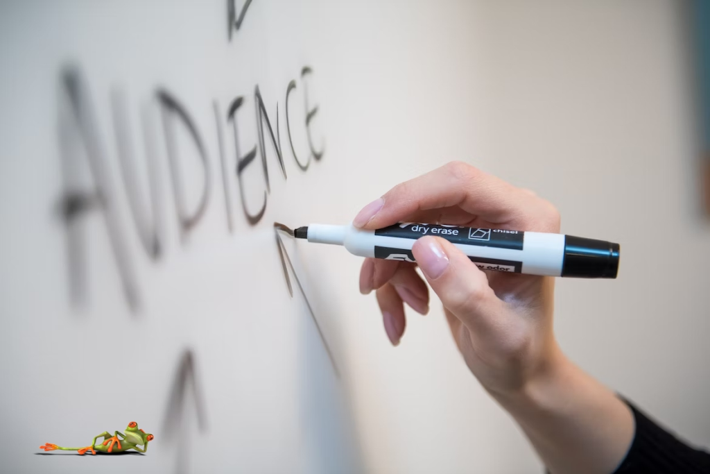 Person writing 'target audience' on a whiteboard - Illustrating the importance of understanding your audience in SEO and digital marketing strategies.